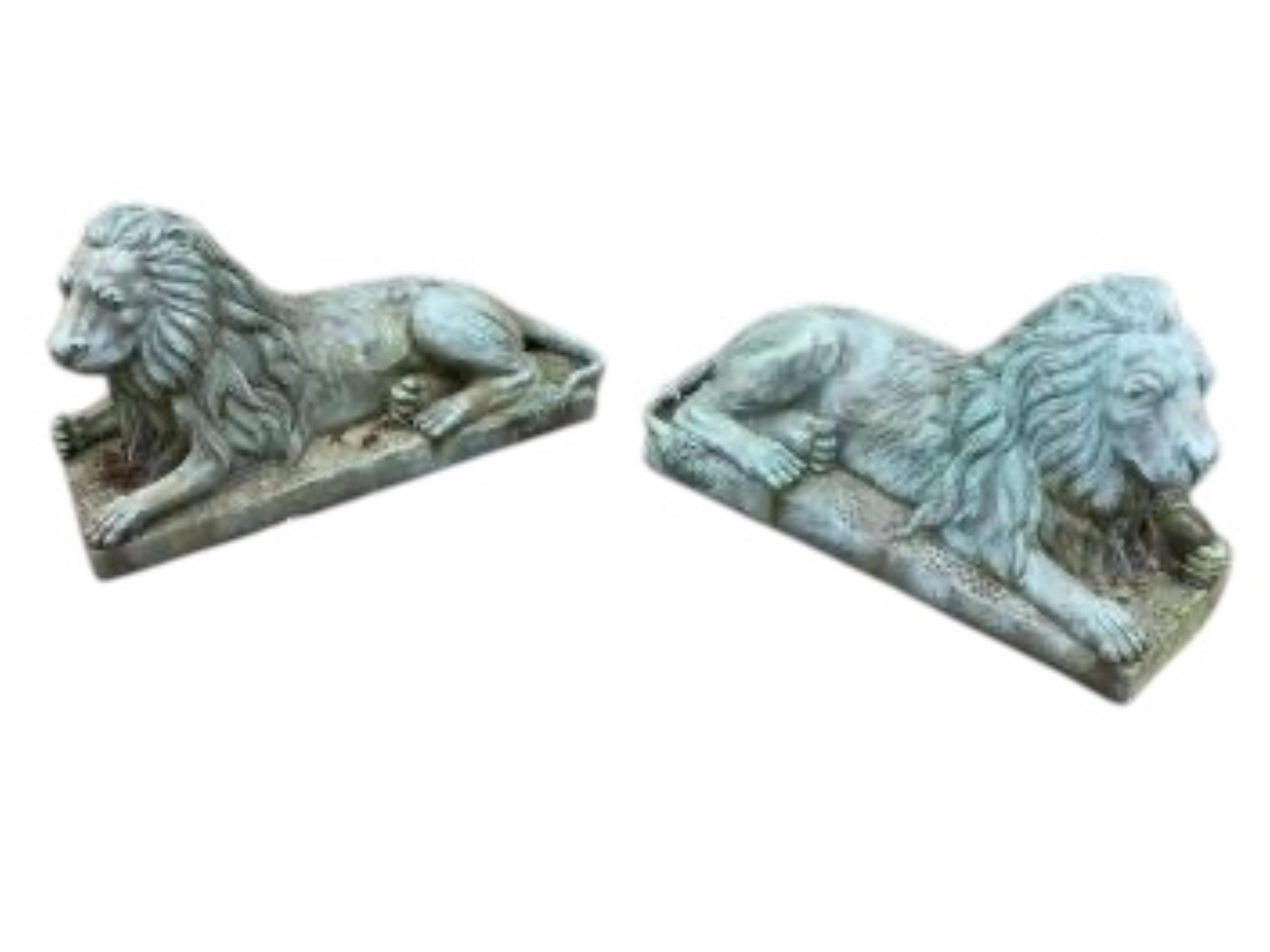 A pair of green patinated cast iron recumbent lions, length 46cm, height 24cm
